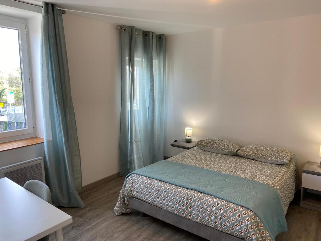 um pequeno quarto com uma cama e uma janela em Maison des Balmes proche Lyon em Miribel
