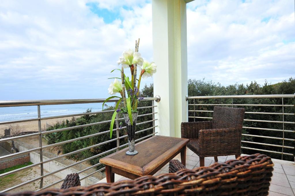 a vase of flowers on a table on a balcony at Hotel Aurora in San Vincenzo