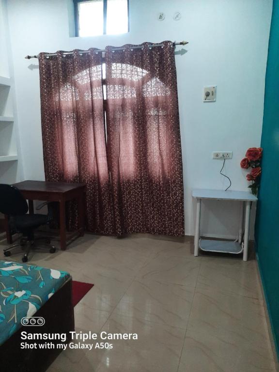 Cette chambre dispose d'un rideau de douche et d'un bureau. dans l'établissement Gokul PG Homestay, à Gorakhpur