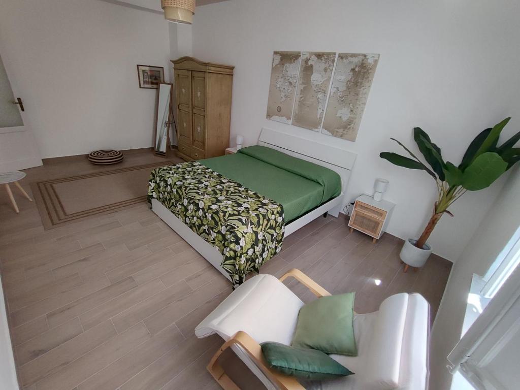 ein Schlafzimmer mit einem grünen Bett und einem Stuhl in der Unterkunft L'Arco Verde in Trabia