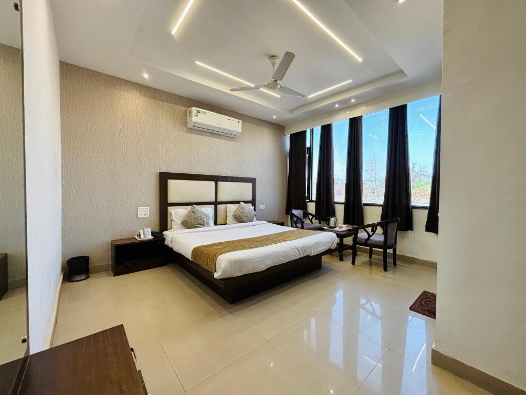 a bedroom with a bed and a table and chairs at Hotel The Benz in Chandīgarh
