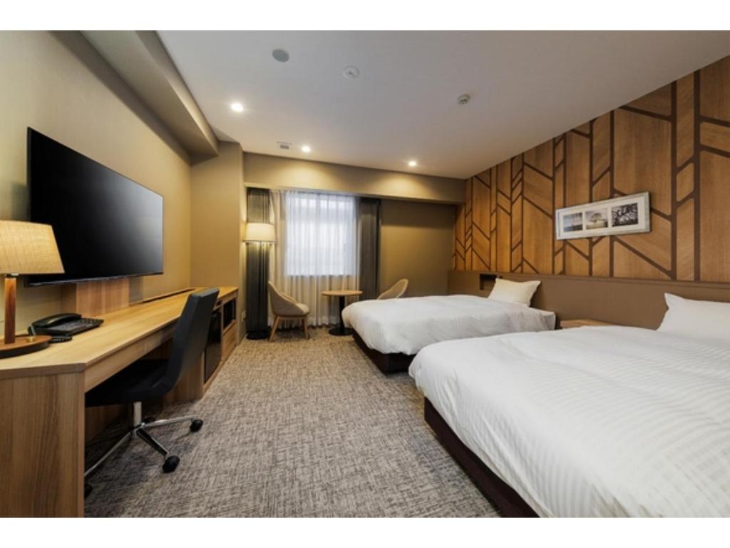 a hotel room with two beds and a desk at Soma Station Hotel - Vacation STAY 40262v in Soma