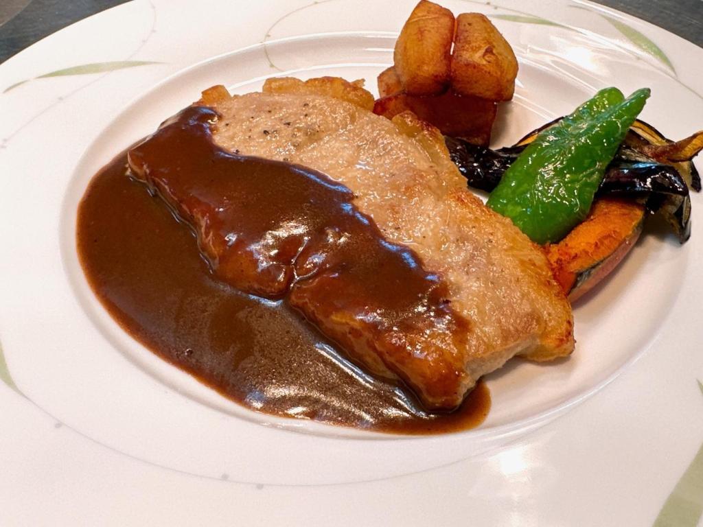 une assiette de nourriture avec de la viande, des pommes de terre et de la sauce dans l'établissement Furano Hops Hotel - Vacation STAY 41833v, à Kami-furano