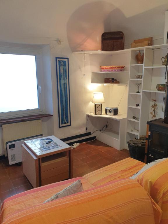 a bedroom with two beds and a table and a window at Pace tra gli ulivi e il mare in Sori