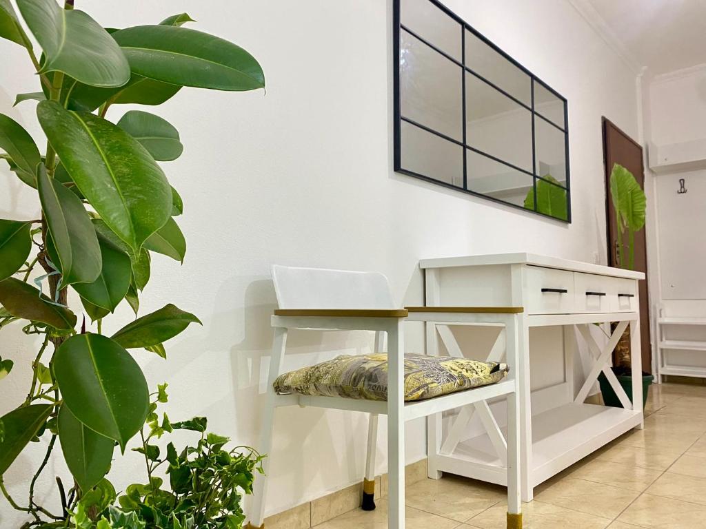 a white desk with a laptop on it next to a plant at Delight City Apartment in Kavajë