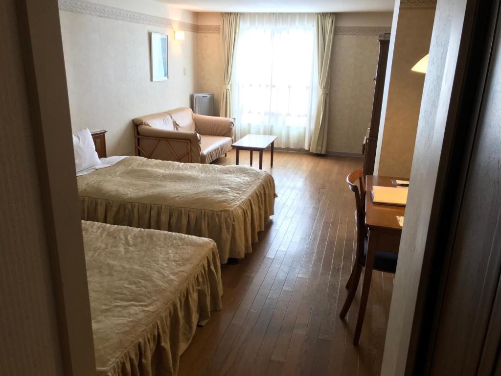 a hotel room with two beds and a chair at Furano Hops Hotel - Vacation STAY 41813v in Kami-furano