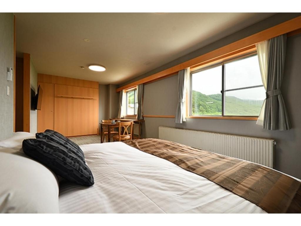 a bedroom with a large white bed with a window at Hotel Takimoto - Vacation STAY 43491v in Yamanouchi