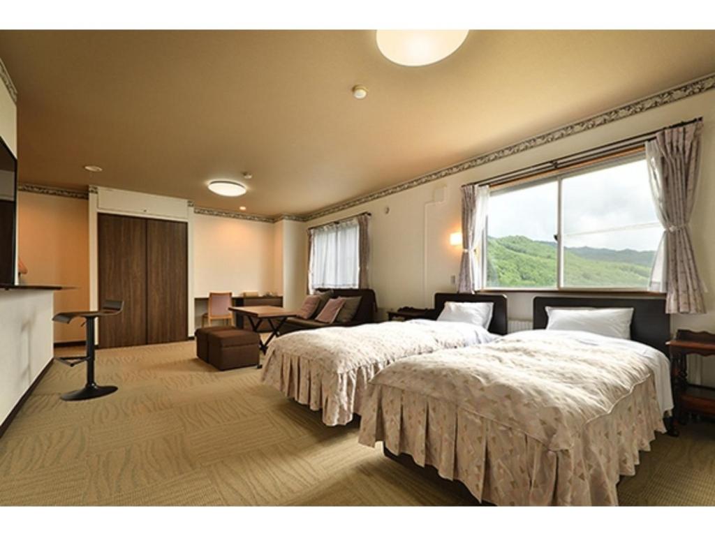a hotel room with two beds and a window at Hotel Takimoto - Vacation STAY 43488v in Yamanouchi