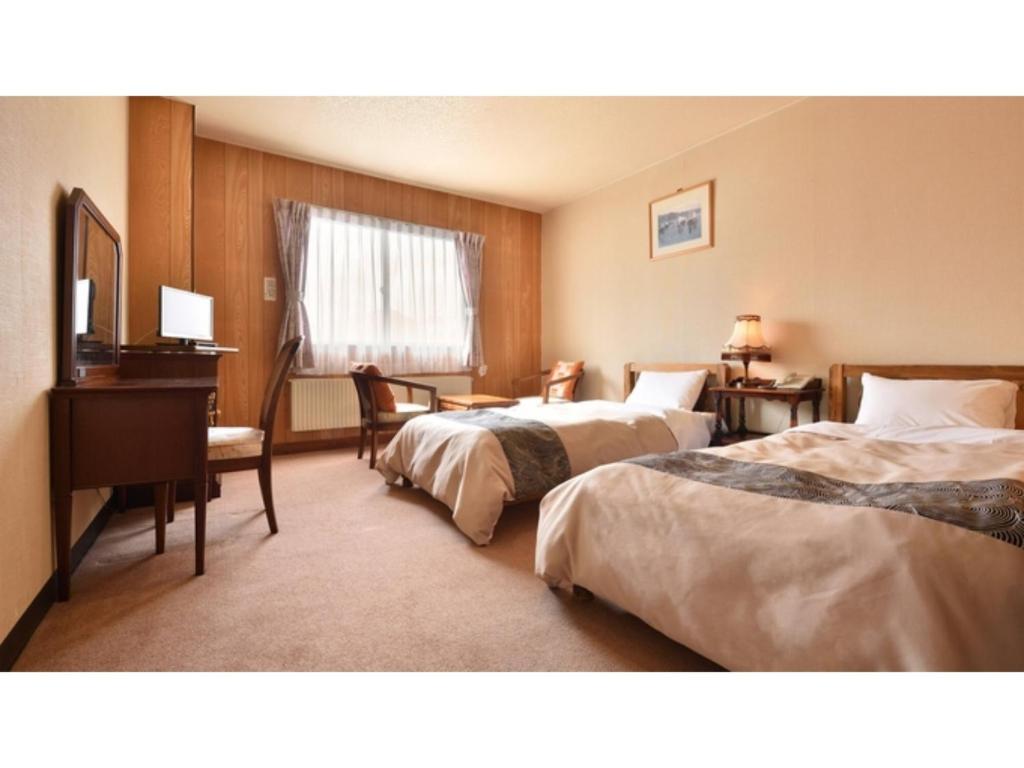 a hotel room with two beds and a desk at Hotel Takimoto - Vacation STAY 43486v in Yamanouchi