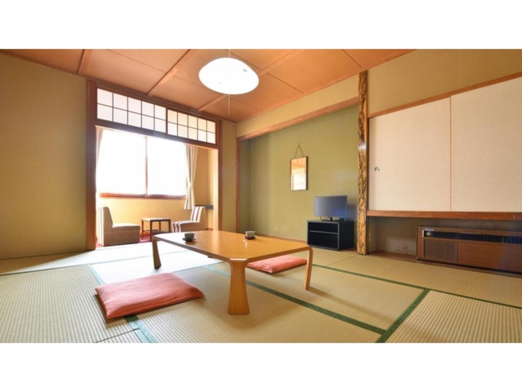 a living room with a table and a kitchen at Hotel Takimoto - Vacation STAY 43489v in Yamanouchi