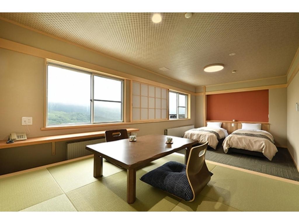 a bedroom with a bed and a table and a bed at Hotel Takimoto - Vacation STAY 43490v in Yamanouchi