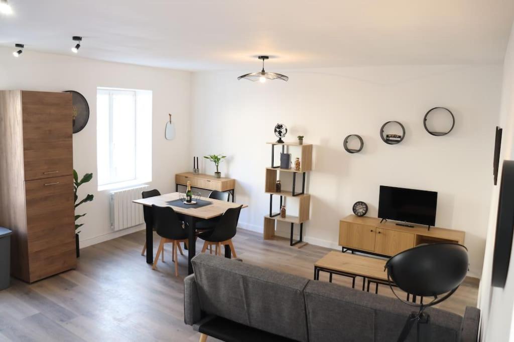 un salon avec un canapé et une table dans l'établissement Appartement spacieux chaleureux, à Roanne
