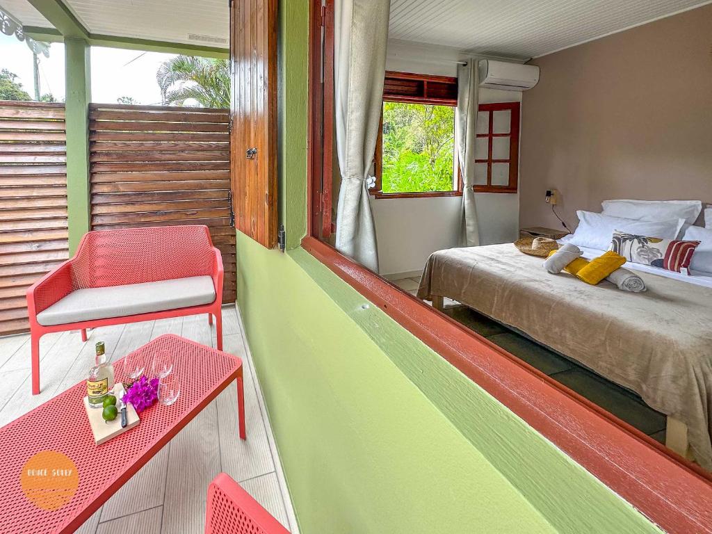 une chambre avec un lit, une table et une chaise dans l'établissement Villa Doucè Soley, à Rivière-Pilote