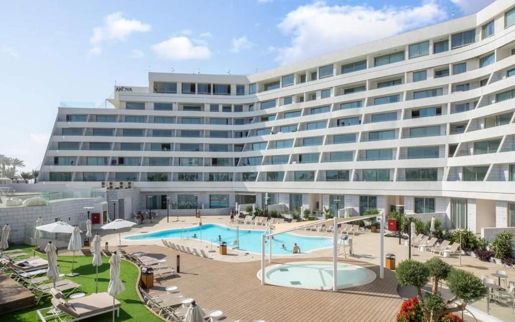 un grande edificio con piscina di fronte di סוויטות עם נוף צמודות לים במתחם SeaSide היוקרתי עם בריכה - By SEAELO EILAT a Eilat