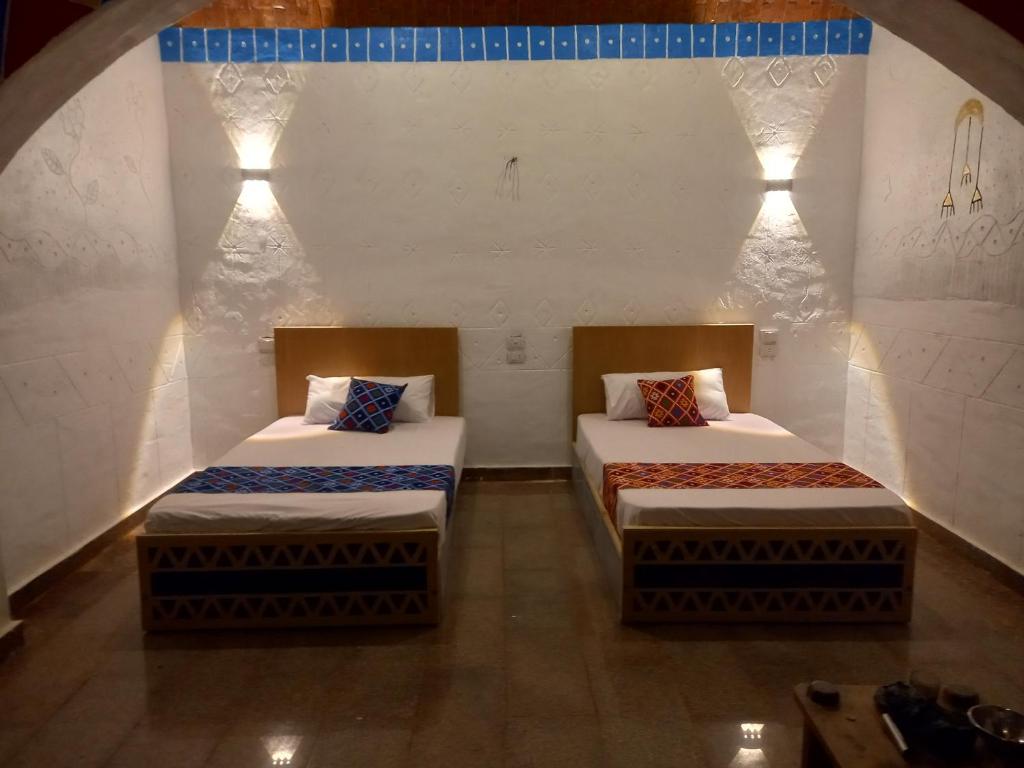 two beds in a room with lights on the wall at Nubian house heaven in Shellal
