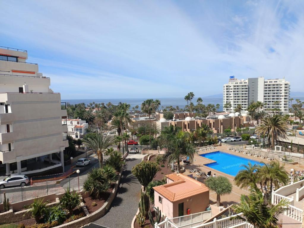 ariaal uitzicht op een stad met een zwembad en gebouwen bij Pretty View Borinquen Playa de las Americas in Playa Fañabe