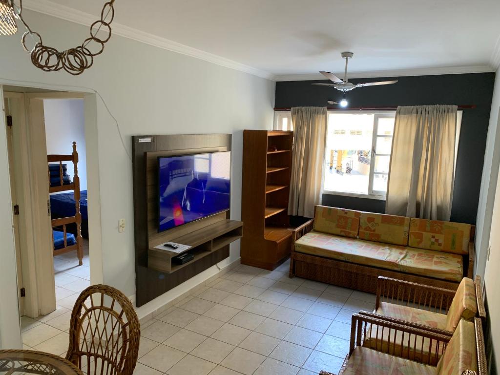 sala de estar con sofá y TV de pantalla plana en Apartamento Guarujá 5min a pé da Praia da Enseada, en Guarujá