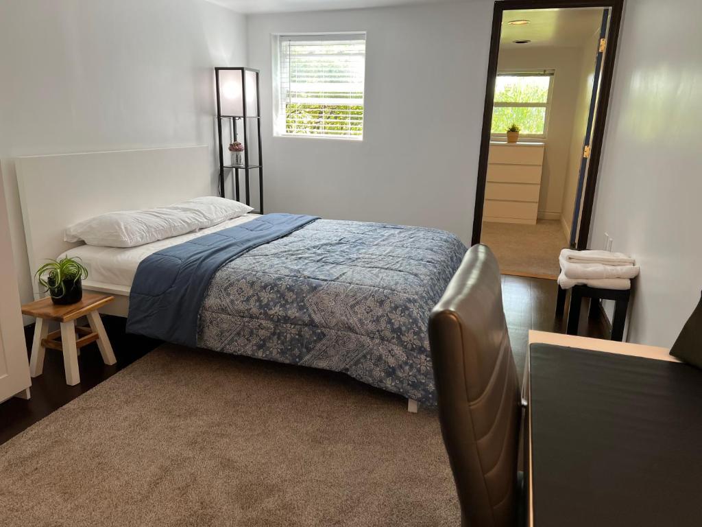 1 dormitorio con 1 cama con manta azul y espejo en City Center Comfort place, en North Vancouver
