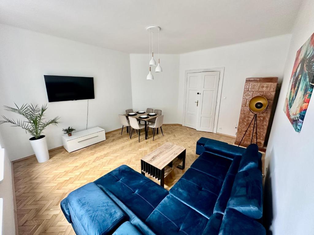 Una sala de estar con un sofá azul y una mesa. en Selected Apartments by market square, en Cracovia