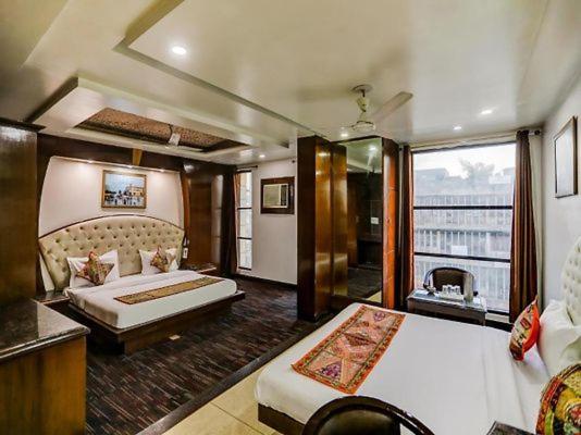 a hotel room with two beds and a large window at HOTEL GEESON INTERNATIONAL-New Delhi Railway Station in New Delhi