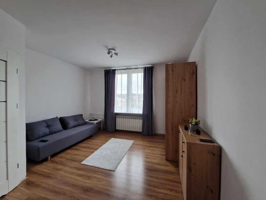 un soggiorno con divano blu e finestra di Mieszkanie na doby dla dwojga a Kraśnik