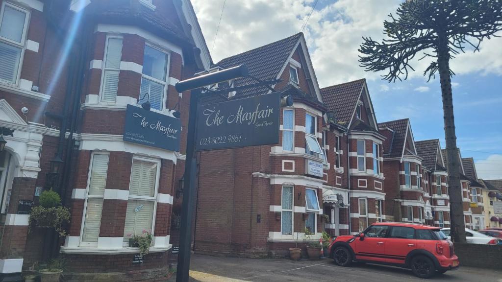 a red car parked in front of a row of houses at The Mayfair guest house self catering in Southampton