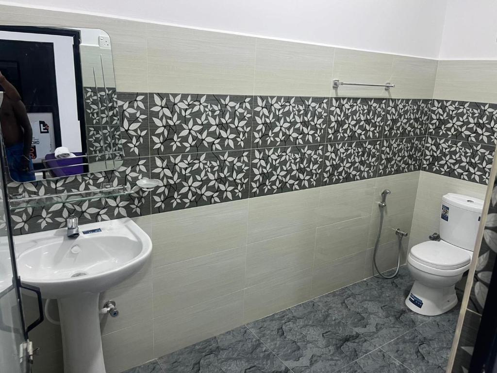 een badkamer met een wastafel en een toilet bij Krishna Bhavan Hotel in Trincomalee