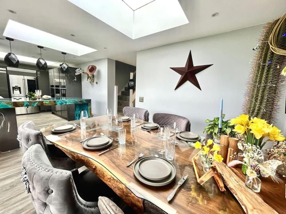 uma mesa de jantar com cadeiras e uma estrela na parede em Longhorn House - Unique & Luxury Home With Hot Tub em Horsham Saint Faith