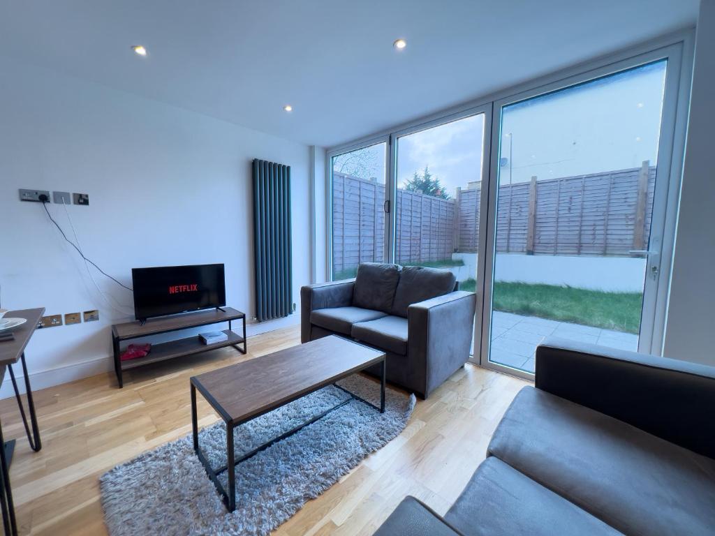 a living room with a couch and a table at Deluxe 3 Bed Flat with garden in Finchley