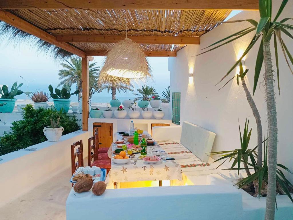 a dining table on a patio with a view of the ocean at Dar El Mahdia by Daldoul in Mahdia