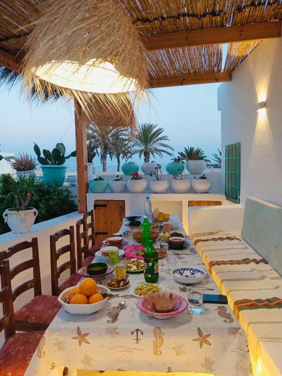a table with food and drinks on a table with chairs at Dar El Mahdia by Daldoul in Mahdia