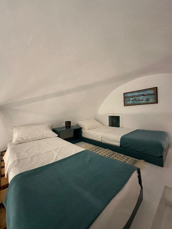 a room with two beds and a couch at Dar El Mahdia by Daldoul in Mahdia