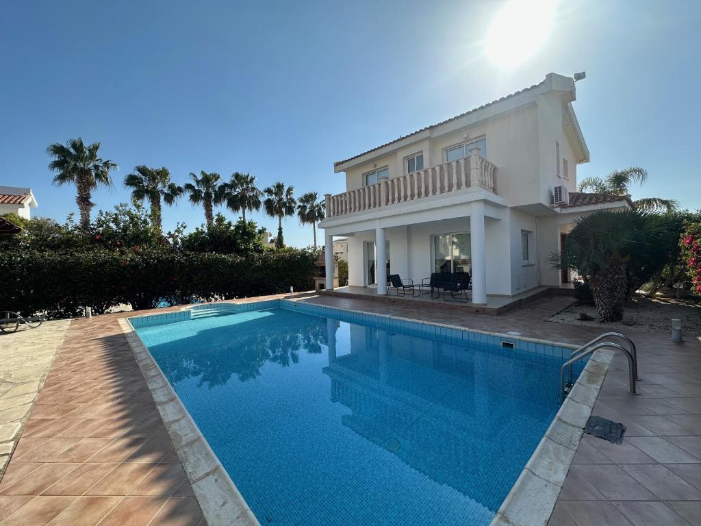 a villa with a swimming pool in front of a house at Villa Demetra, Coral Bay in Coral Bay