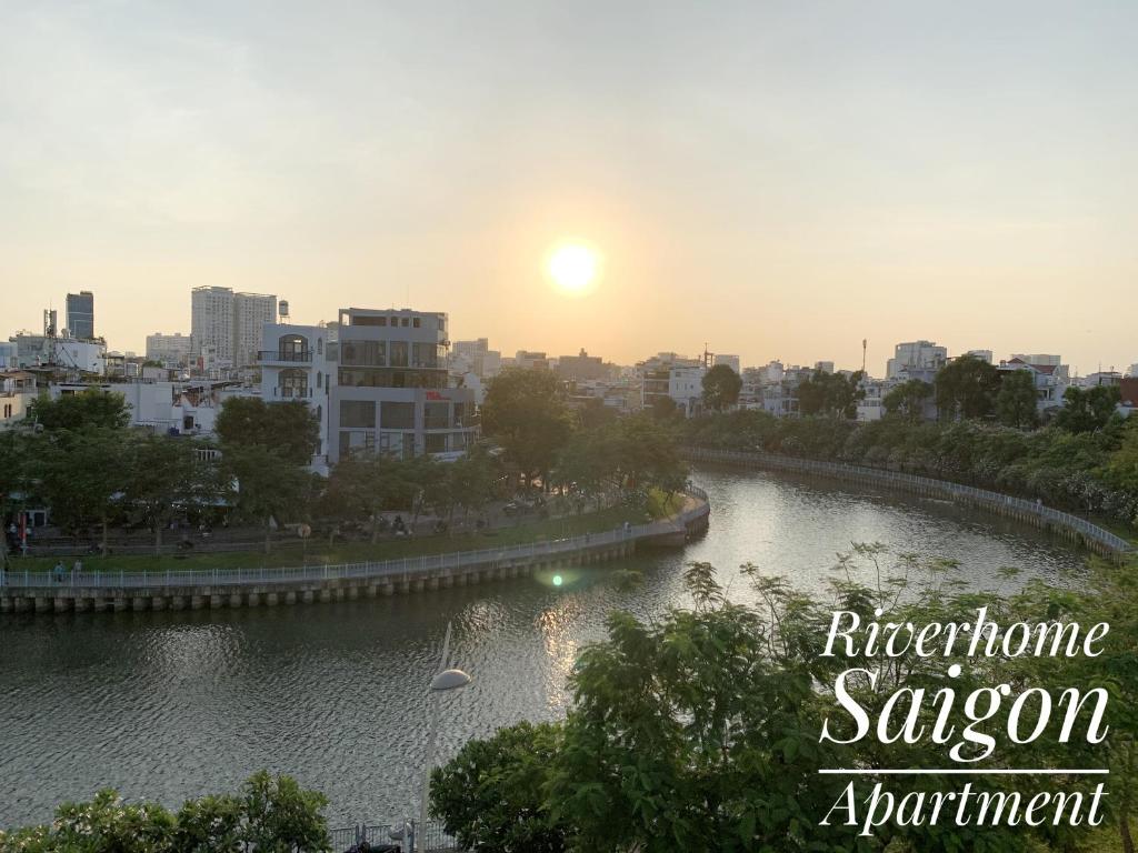 une rivière dans une ville avec le coucher du soleil en arrière-plan dans l'établissement Riverhome Saigon Apartments, à Hô-Chi-Minh-Ville
