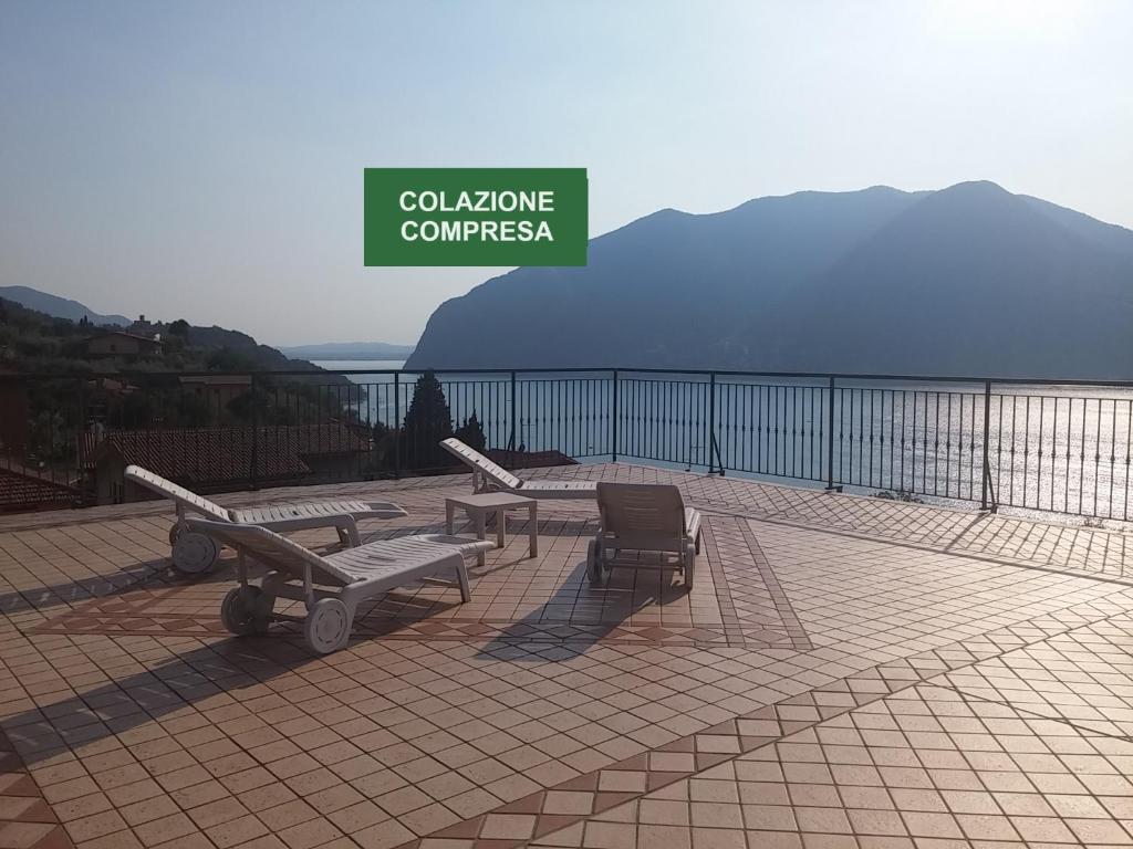 patio con tavolo, sedie e cartello di Hotel Bellavista Meublè a Monte Isola
