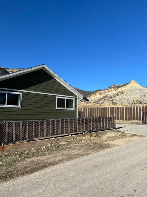 a green house with a fence next to a road at Helper Sunrise Peak in Helper