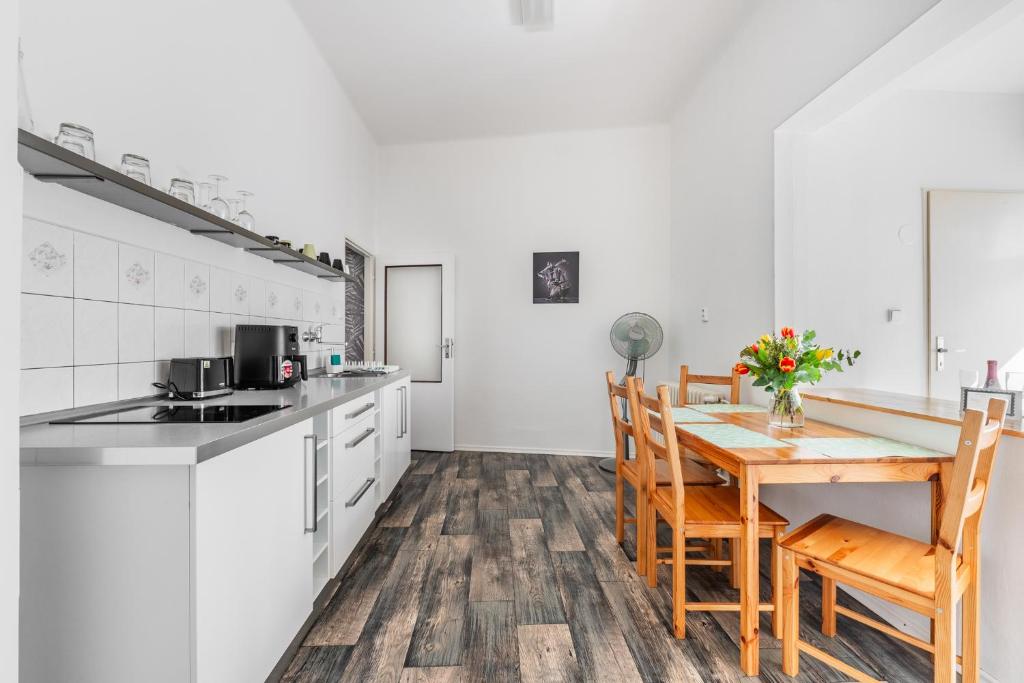 uma cozinha com armários brancos e uma mesa e cadeiras de madeira em Apartmány Rozárka Turnov em Turnov