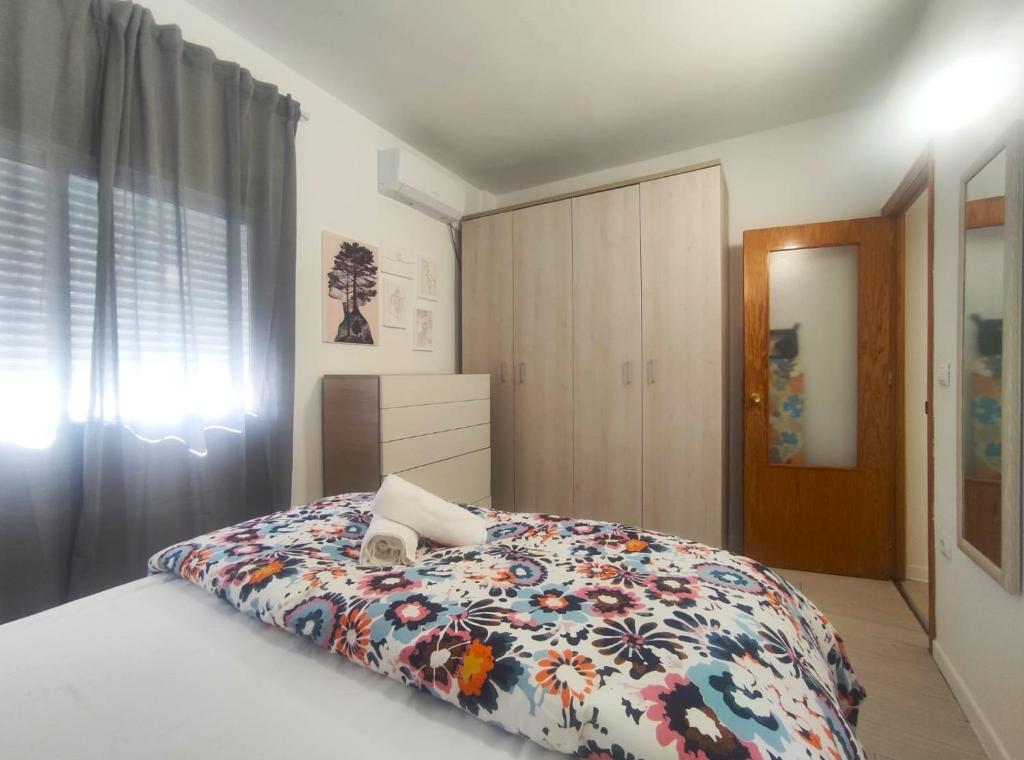 1 dormitorio con 1 cama con edredón de flores en Apartamentos Rincón del Roldán - La Rinconada, en San José de La Rinconada