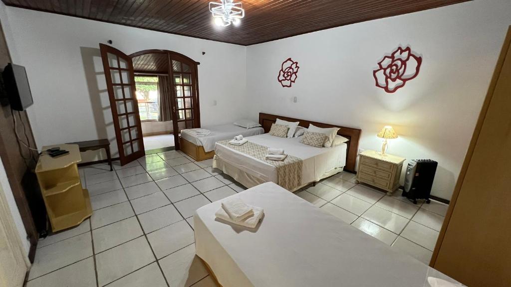 a room with two beds and a tv in it at Biazi Paradise Hotel in Serra Negra