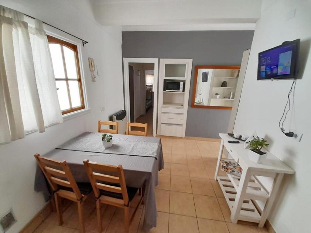 cocina y comedor con mesa y sillas en Departamento 4 personas Colon 2900 en Mar del Plata