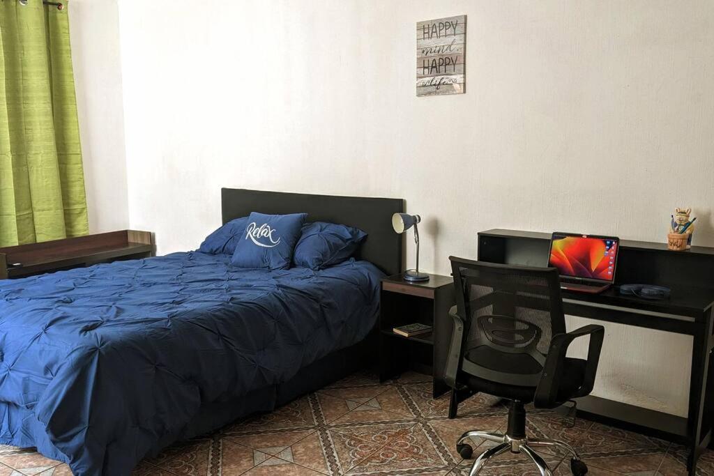 a bedroom with a bed and a desk and a chair at Apartment in Colonia Molina in Quetzaltenango