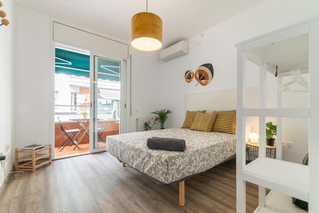 a white bedroom with a bed and a balcony at VALLH in Barcelona
