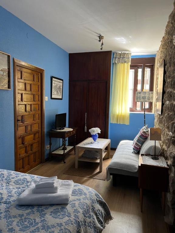 Habitación azul con 2 camas y escritorio. en La Venta de Izan, en Gumiel de Hizán
