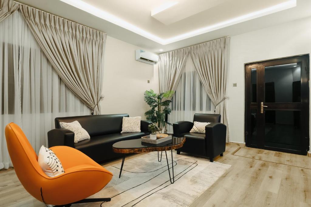 a living room with a couch and chairs and a table at Kashco Apartments Wuse 2 Abuja in Abuja
