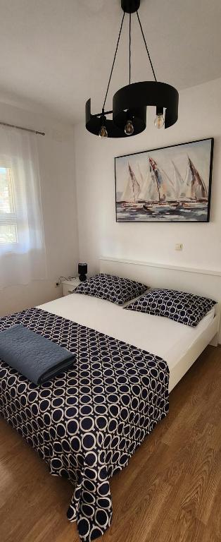 een slaapkamer met een bed met een zwart-wit dekbed bij Apartments Kapetanovi Dvori in Trogir