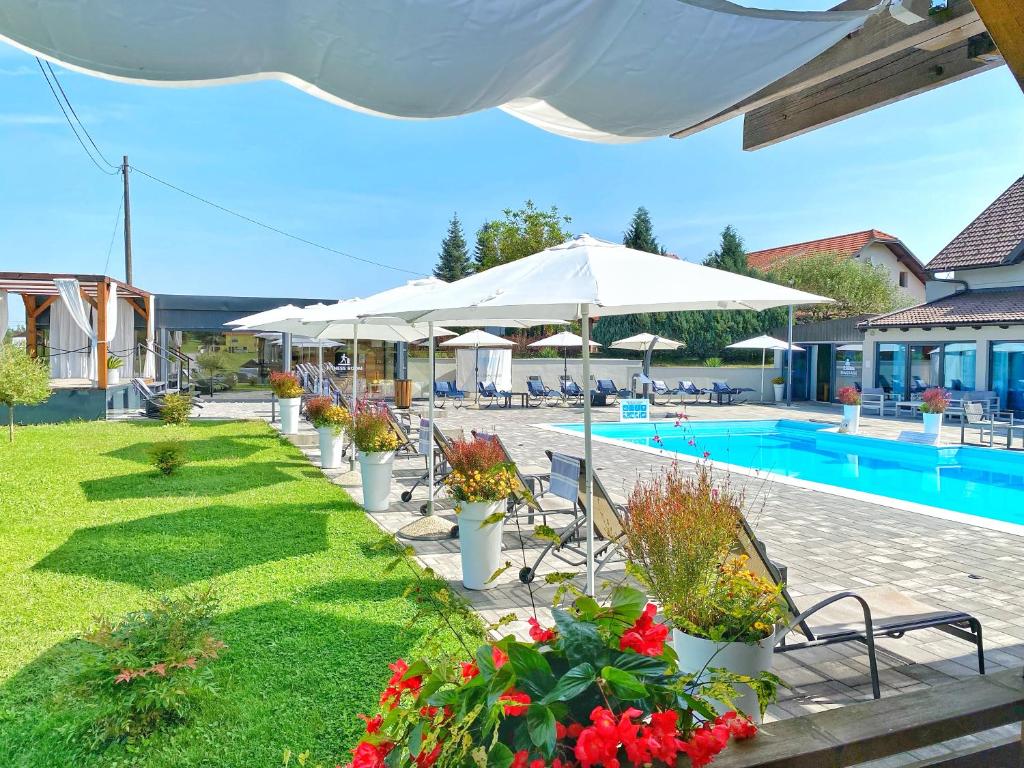 una piscina con sillas y sombrillas junto a un complejo en 16 Lakes Guesthouse, en Grabovac