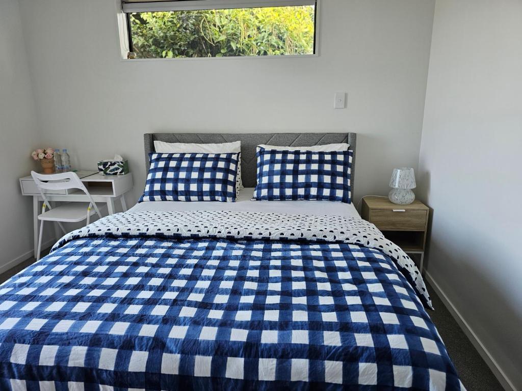 a blue and white bed in a bedroom with a window at Hillcrest Home in Hamilton