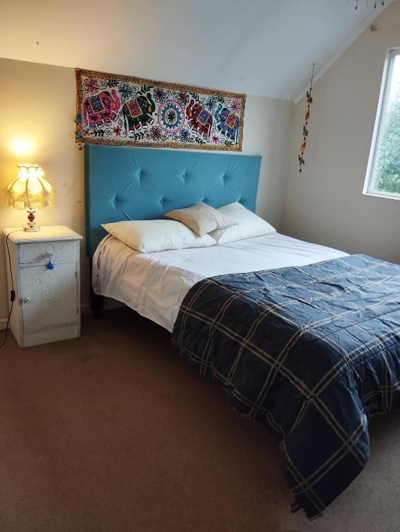 uma cama com uma cabeceira azul num quarto em Casa 3 dormitorios 3 baños Osorno em Osorno