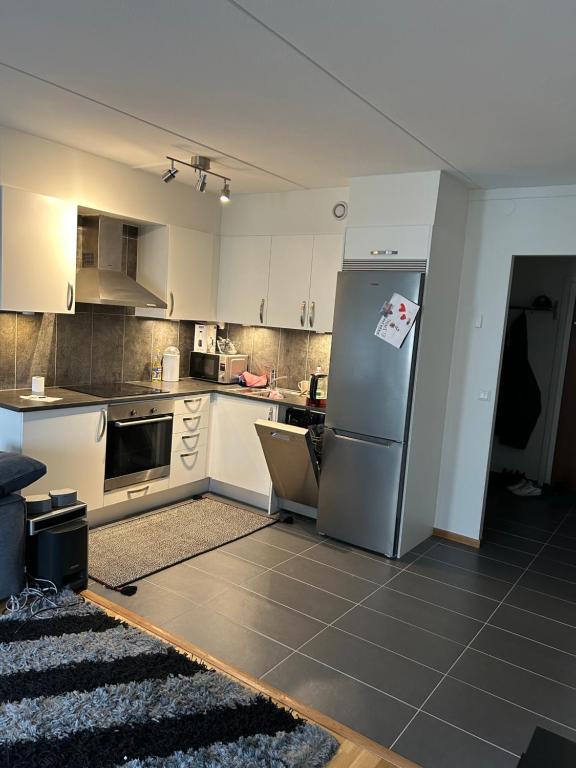 cocina con armarios blancos y nevera en Blessed home, en Estocolmo