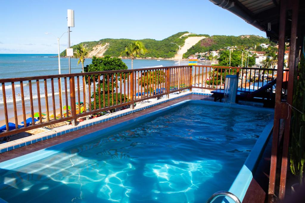 a swimming pool with a view of the beach at Hotel Pousada Azzurra in Natal